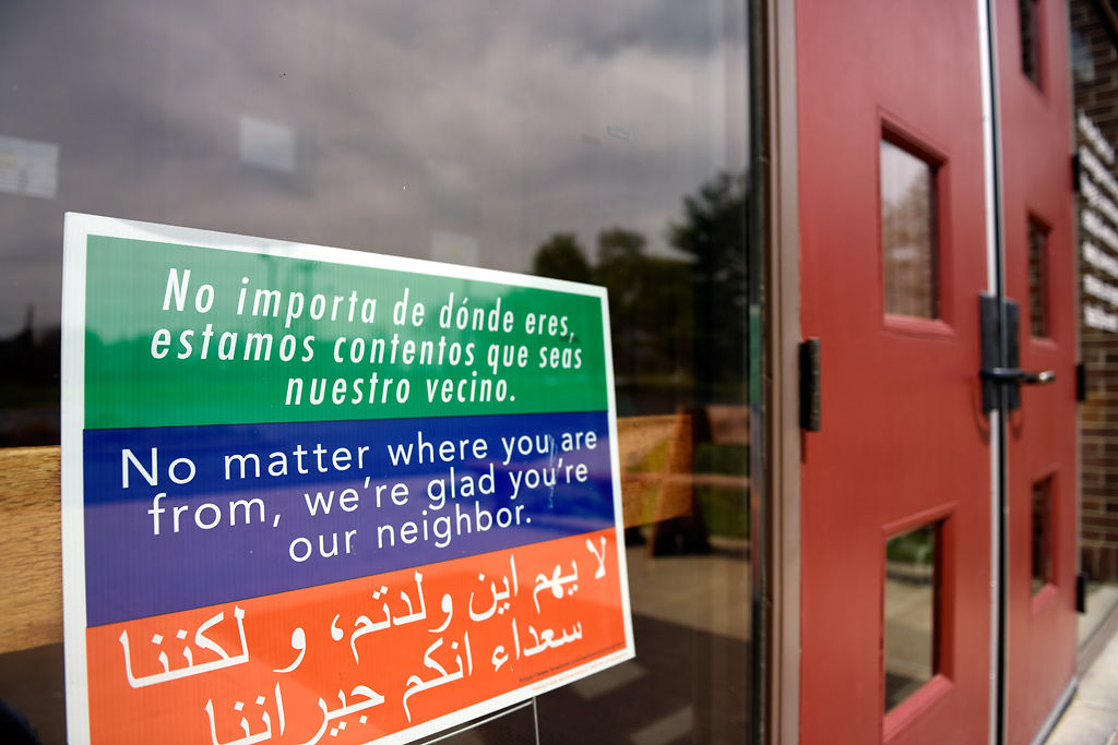 A sign welcoming visitors sits in the window
